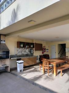 a patio with a table and chairs and a kitchen at Cantinho Real in Ilhéus