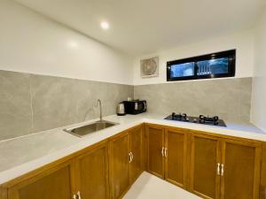 a kitchen with wooden cabinets and a sink at Palmera El Nido Inn in El Nido