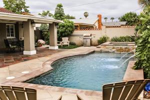 a pool in a yard with chairs and a house at Destination #10 in Anaheim