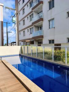 a swimming pool in front of a building at Cantinho Real in Ilhéus