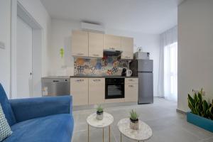 a living room with a blue couch and a kitchen at Dar One - Self catering & self check in apartments by Tritoni Hotels in Il-Gżira