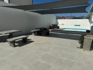 a patio with picnic tables and a swimming pool at St Clouds Strand in Strand +19 photos