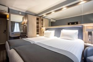 a hotel room with a large bed and a desk at Holiday Inn Glasgow City Theatreland by IHG in Glasgow