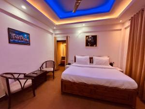 Dwapar Hill Top Near Mall Road في موسوري: غرفة نوم بسرير وسقف ازرق