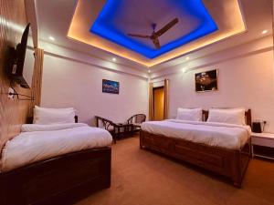 Dwapar Hill Top Near Mall Road في موسوري: سريرين في غرفة ذات سقف أزرق
