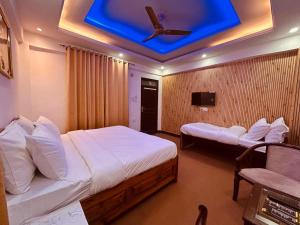 Dwapar Hill Top Near Mall Road في موسوري: غرفة نوم بها سريرين وسقف أزرق