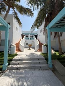 a staircase leading to the front of a house with palm trees at درة العروس بردايس - wave castle in Durat  Alarous +3 photos