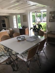 a dining room table with chairs and a laptop on it at Villa Fiquefleur in Fiquefleur-Équainville