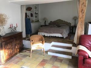 a bedroom with a bed and a couch and a chair at Villa Fiquefleur in Fiquefleur-Équainville