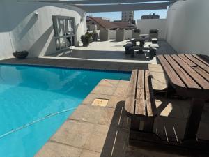 a wooden bench sitting next to a swimming pool at St Clouds Strand in Strand +20 photos