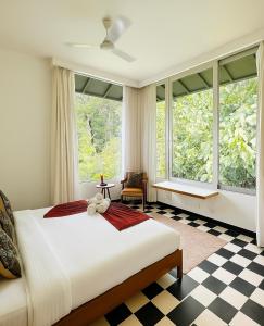 a bedroom with a large bed and large windows at Casa Calma - 2BHK Luxury Villa with Private Pool by evaddo in Siolim