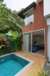 a house with a swimming pool in front of it at Casa Calma - 2BHK Luxury Villa with Private Pool by evaddo in Siolim