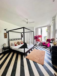 a bedroom with a canopy bed and a rug at Casa Calma - 2BHK Luxury Villa with Private Pool by evaddo in Siolim