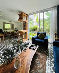 a living room with a blue couch and a table at Casa Calma - 2BHK Luxury Villa with Private Pool by evaddo in Siolim