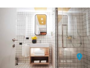 a bathroom with a sink and a shower with a mirror at TriplyRooms Collection - Eur in Rome
