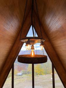 ein Kronleuchter, der von der Decke hängt, mit einem Fenster in der Unterkunft Wildcabinpanoramic Marisel in Mărişel