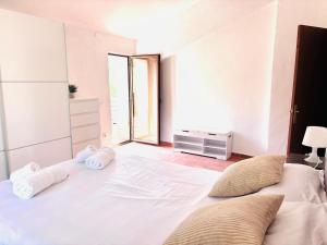 a bedroom with a large white bed with towels on it at Hostalet d'Horta in Santa María de Horta