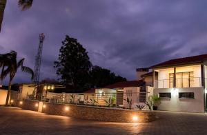 a house with a fence and lights in front of it at Simphiwe Guesthouse in Manzini