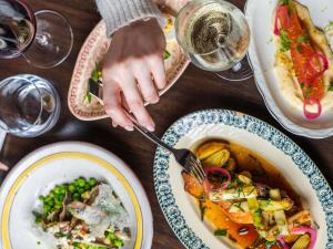 a person eating a bowl of food on a table at Hotel Mercure Château de Fontainebleau in Fontainebleau