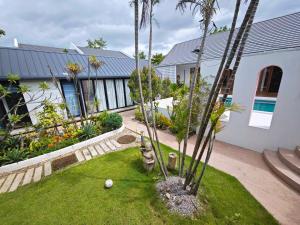 een tuin met palmbomen en een huis bij Fieldlight pool Villa- riceview terrace in Mae Rim