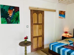a bedroom with a bed and a wooden door at Mountain seaview Cabanas in Tangalle
