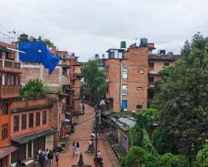 a group of people walking down a street with buildings at 'Timeless Bhaktapur Home' in Bhaktapur +8 photos