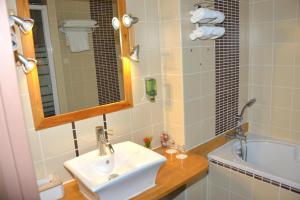 a bathroom with a sink and a bath tub at Best Western Golf d'Albon in Albon