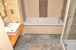 a bathroom with a tub and a sink at Best Western Golf d'Albon in Albon