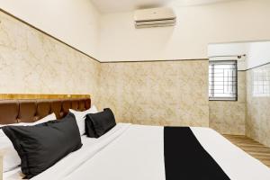 - une chambre avec un lit blanc et des oreillers noirs dans l'établissement Hotel O NG COMFORTS, à Bangalore