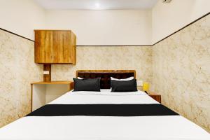 une chambre avec un grand lit avec une tête de lit en bois dans l'établissement Hotel O NG COMFORTS, à Bangalore