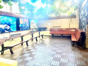 a row of benches in a room with an aquarium at Waikiki Seaside Monarch Paradise Hotel Room Greenery Mountain View in Honolulu