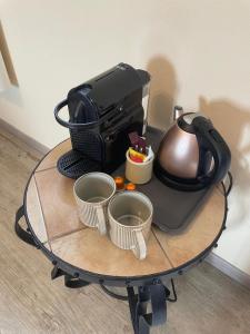 a coffee maker on a table with cups on it at La Fermette Champenoise in Jonquery