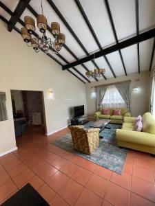 a living room with two couches and a tv at Carrington Guest House in Durban
