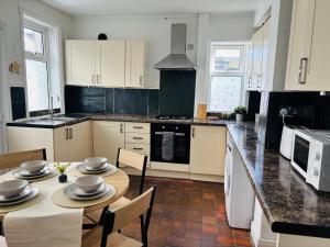 a kitchen with a table with chairs and a counter top at Wallasey Nest in Wallasey