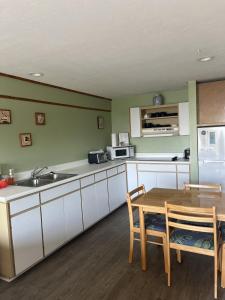 a kitchen with white cabinets and a wooden table at Unit 225 Beautiful Cedar key in Cedar Key