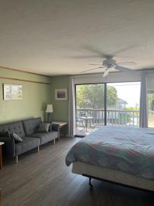 a bedroom with a bed and a couch and a window at Unit 225 Beautiful Cedar key in Cedar Key