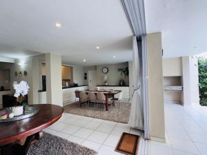 a living room and kitchen with a table and a dining room at Olives by Agnes 31 in Hartbeespoort
