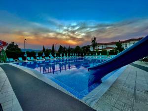 a large swimming pool with a slide and chairs at Elegance Spa Hotel in Ognyanovo +37 photos