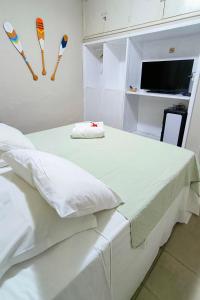 a white bedroom with a bed with kites on the wall at Casa Swell Hostel in Fernando de Noronha