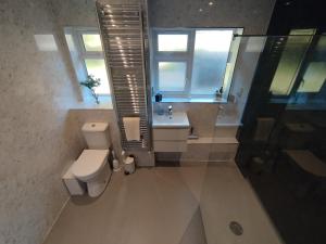 une salle de bain avec toilettes, lavabo et fenêtre dans l'établissement White Cliff Rest, à Seaford 18 autres photos