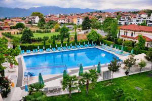 an overhead view of a large swimming pool with blue chairs at Elegance Spa Hotel in Ognyanovo