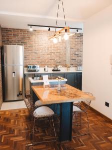 a kitchen with a wooden table with chairs and a refrigerator at Casa Brown in Neuquén