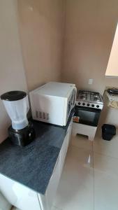 eine Küche mit einer Mikrowelle und einem Mixer auf der Theke in der Unterkunft Hospedagem, casa Palmas, Conforto e Qualidade in Palmas + 27 Fotos