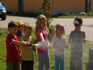 a group of young children playing with a water hose at Holiday home in Markkleeberg near a lake in Markkleeberg