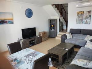 Una sala de estar con un sofá y un televisor. en Casa Spa, en Polop