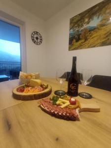 a table with a bottle of wine and a plate of food at Panorama Wildgrat in Fliess +22 photos