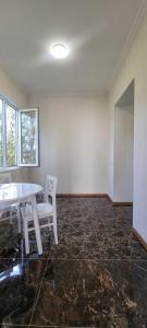 Tskhaltubo Spa Resort Apartments في Itʼkhvisi: غرفة فارغة مع طاولة بيضاء وكراسي +6 صور