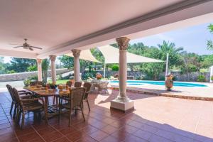 an outdoor patio with a table and chairs and a pool at Can Joan Vich ii in Can Furnet