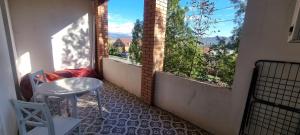 Tskhaltubo Spa Resort Apartments في Itʼkhvisi: بلكونه مع طاوله و نافذتين مع اطلاله