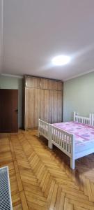 Tskhaltubo Spa Resort Apartments في Itʼkhvisi: غرفة نوم بسريرين بيض وارضية خشبية